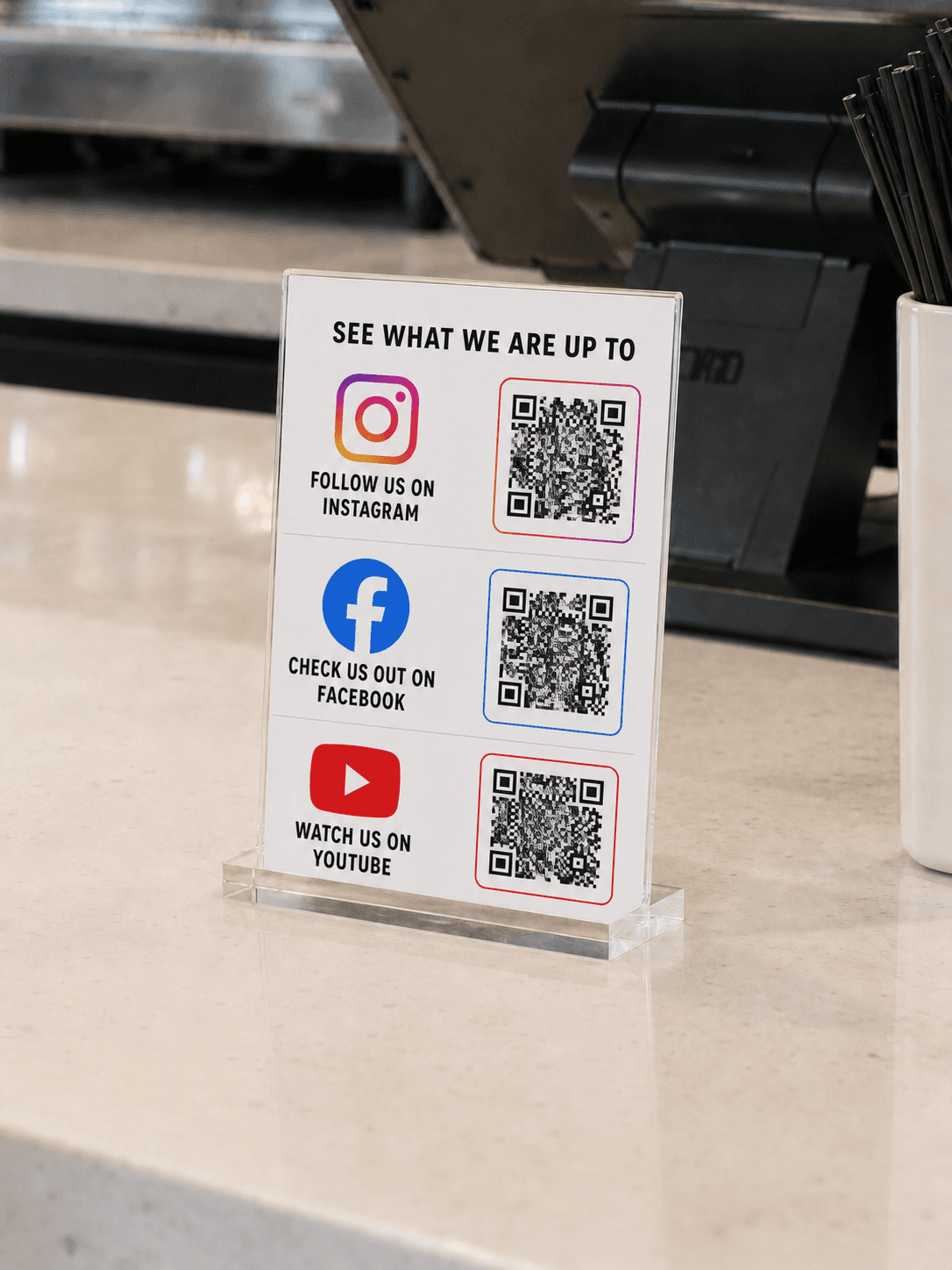Instagram, Facebook, and YouTube QR Display on a checkout counter